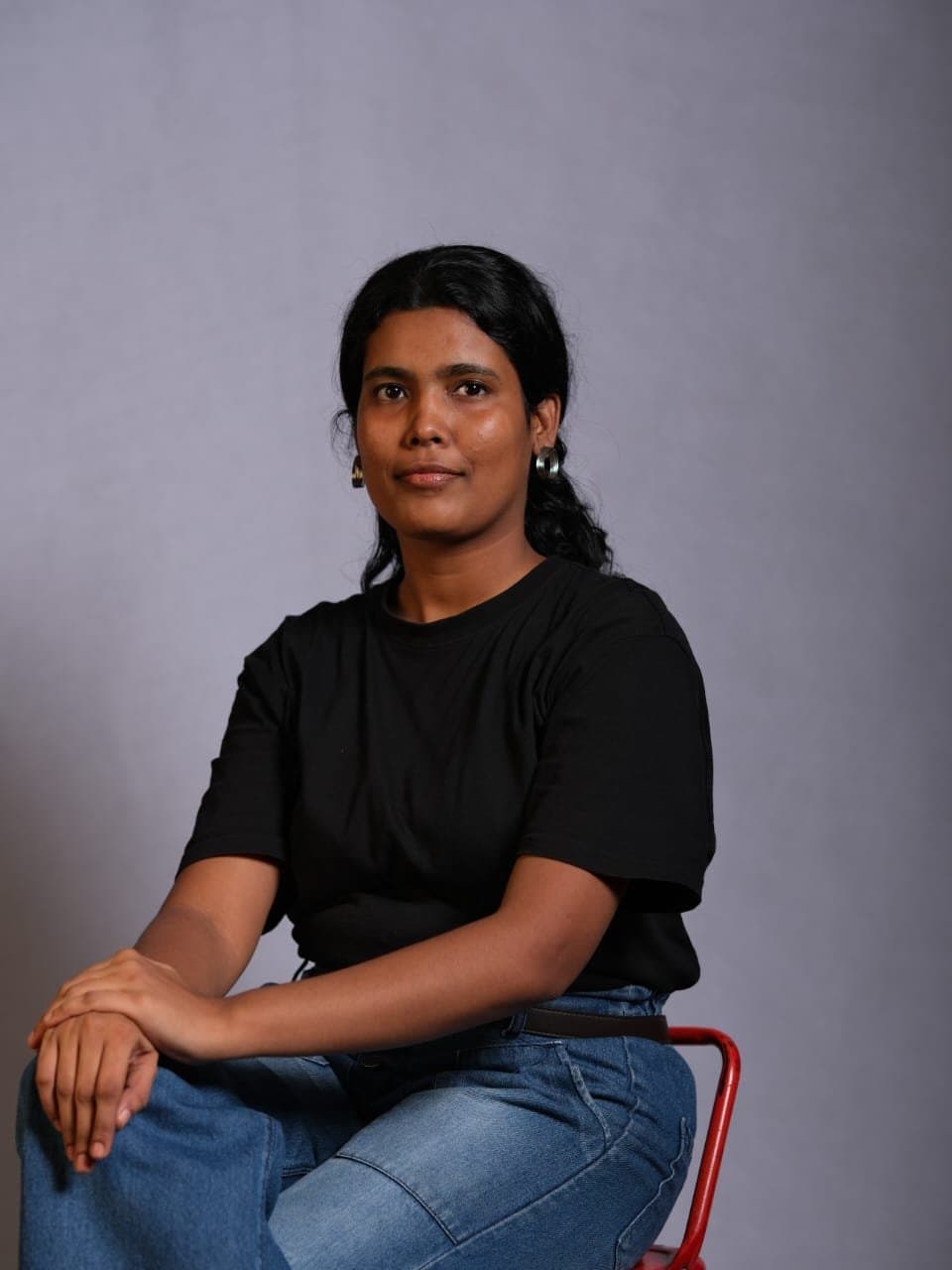 Portrait of Anukriti Tripathi seated against a grey backdrop