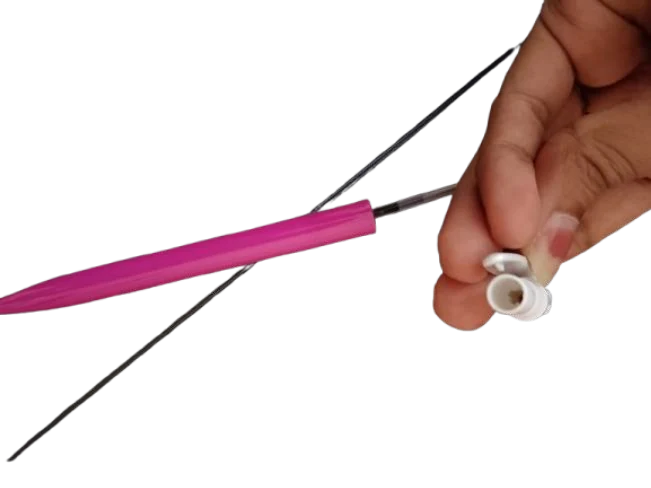 A pink plastic click pen taken apart with the refill and spring visible