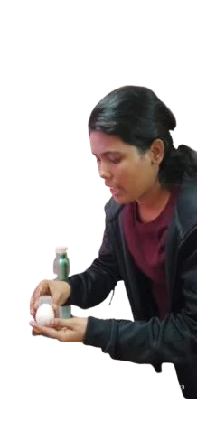 A person holding an egg with a small cap placed over its top