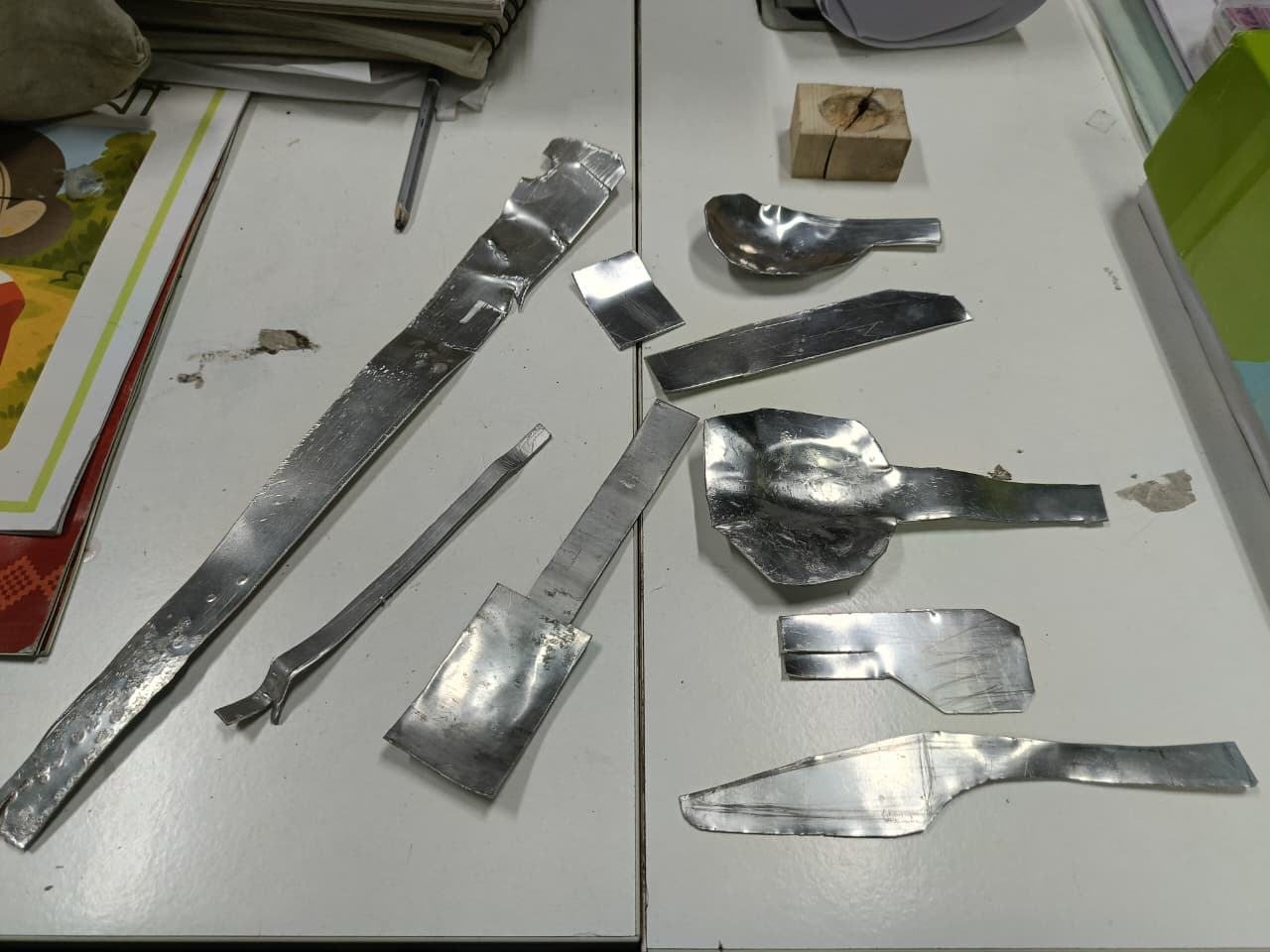 Early aluminium spoon and fork pieces laid out on a table