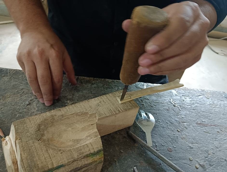 Carving a wooden handle on a block