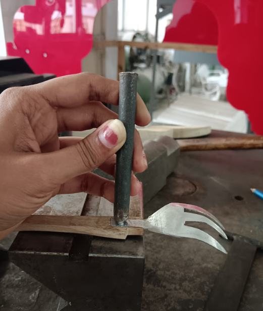 Hammering a rivet on an anvil