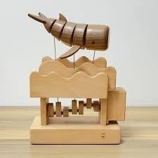 A wooden whale automaton above a wave-shaped cam box