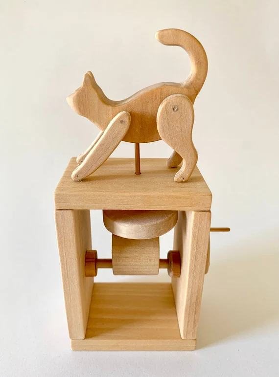 A wooden cat automaton on an open frame