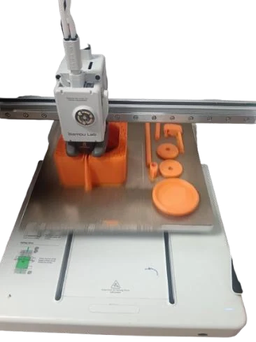 Orange cam discs and shaft parts printing on the bed