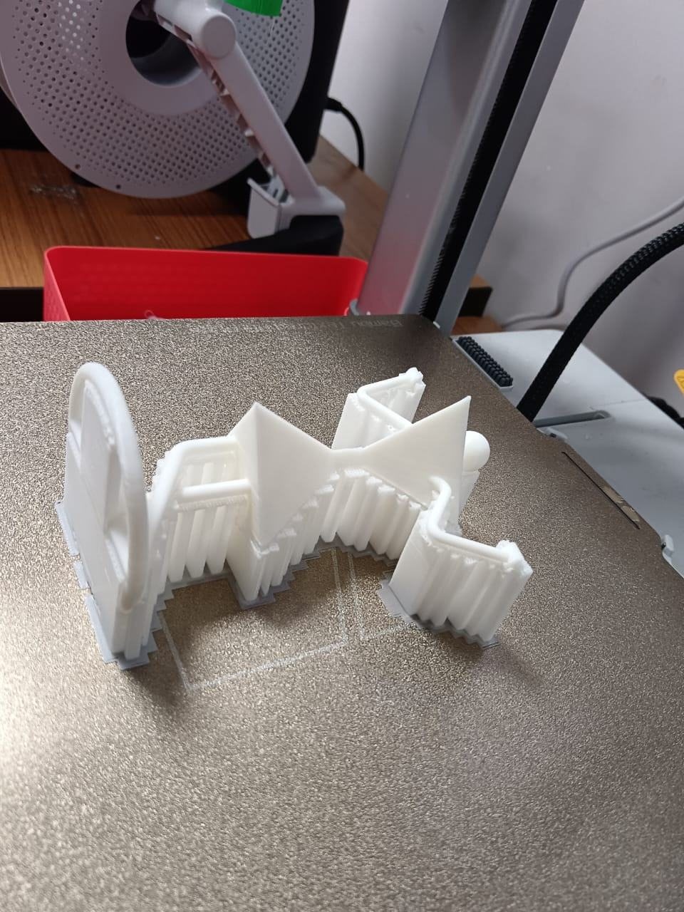 The printed model on the bed beside the printer